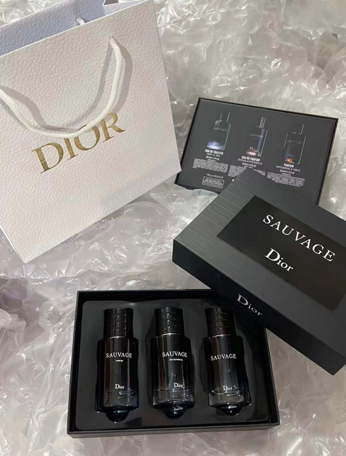 authentic designer fragrances displayed in a Dior Sauvage gift set and bag.