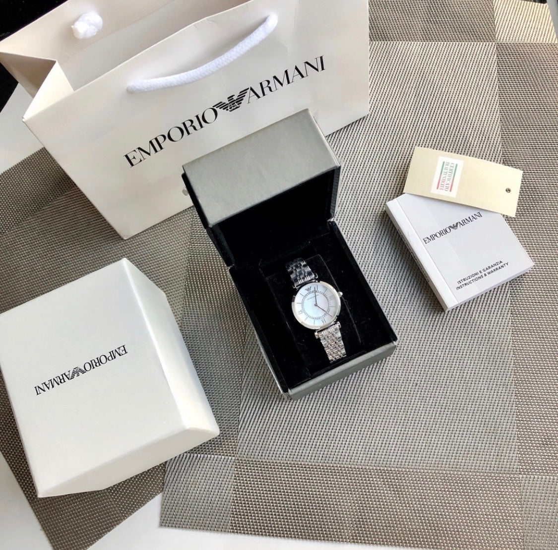 Shop authentic designer fashion UK - Emporio Armani watch in box with shopping bag and tags.